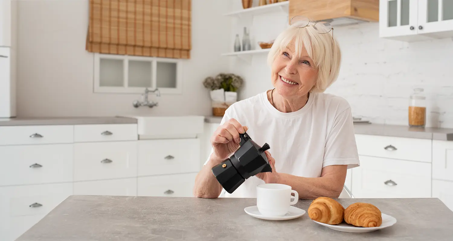 Zufriedene Seniorin genießt entspannten Morgen in sauberer Küche – dank professioneller Haushaltshilfe in Fürstenwalde